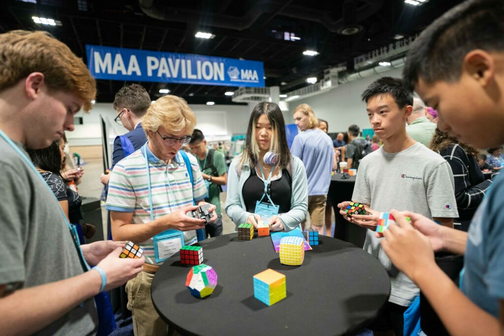 MAA AMC students play with Rubik's Cubes at MAA MAthFest in 2023.